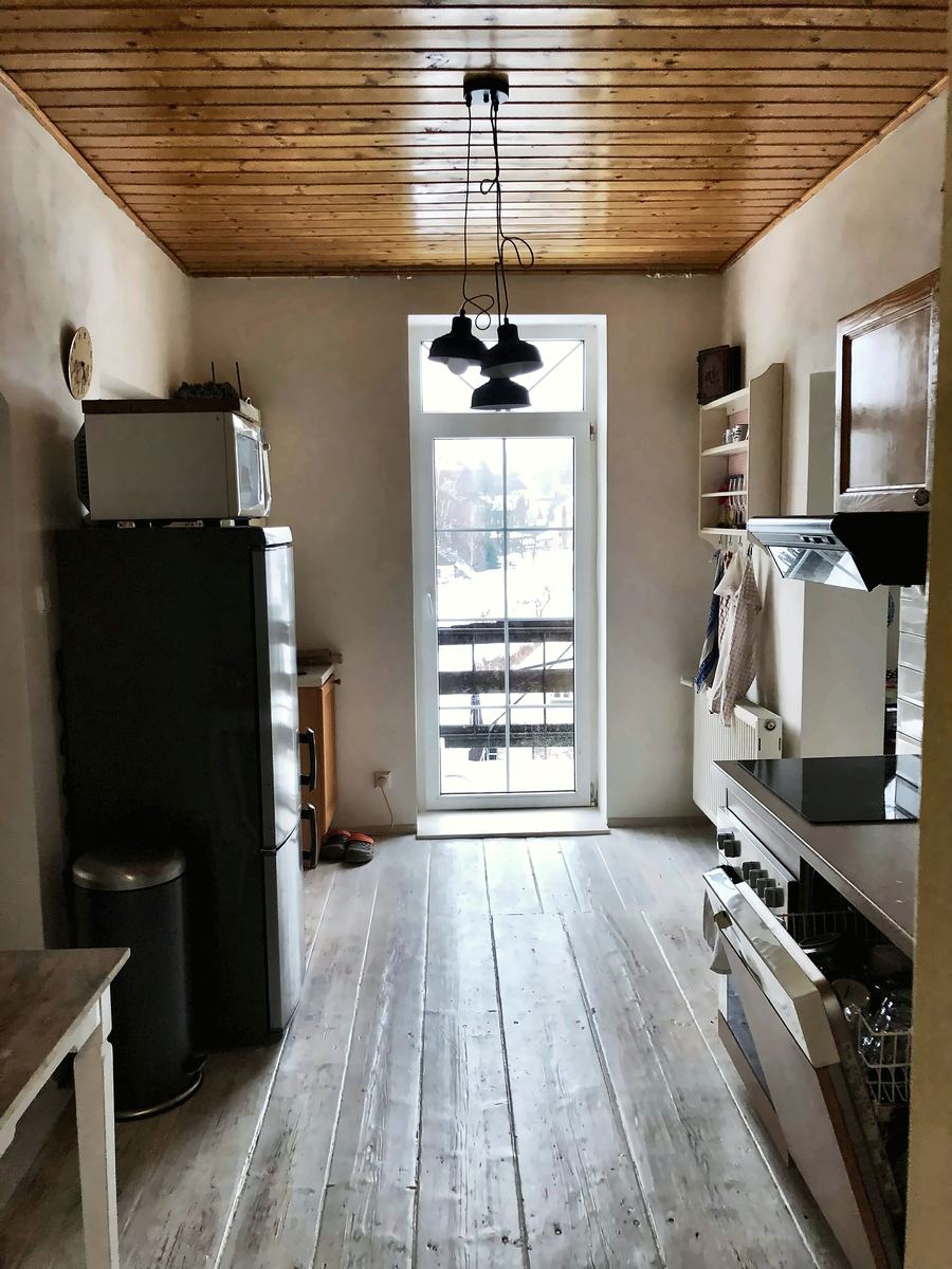 Kuchyně s dřevěným stropem a prosklenými dveřmi na balkon